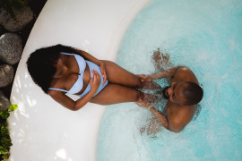 Koppel geniet in het lotusbad tijdens wellness babymoon.