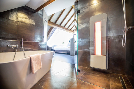 Luxe open badkamer in piramide suite met losstaand bad en inloopdouche.