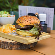 Black Angus burger met augurk, krokante ui, rode ui, spek, Cheddar en truffelcrème in Restaurant Bread & Bites.