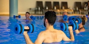 Fysiotherapeut begeleidt een les AquaFit in het thermale water van het oefenbad bij Thermae 2000.